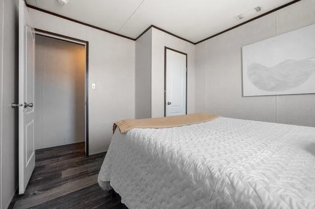 a bedroom with a bed and wooden floor