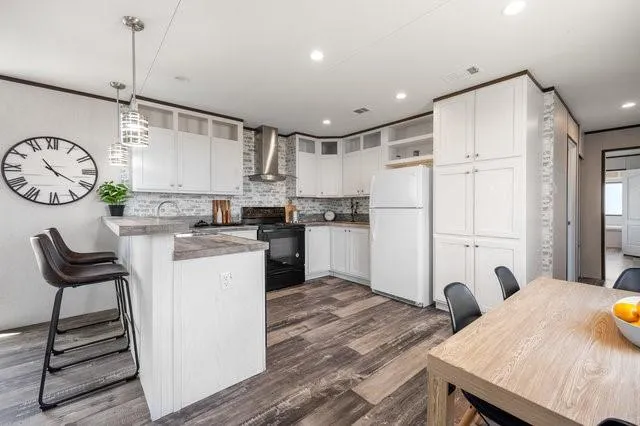 a kitchen with a refrigerator a stove and white cabinets
