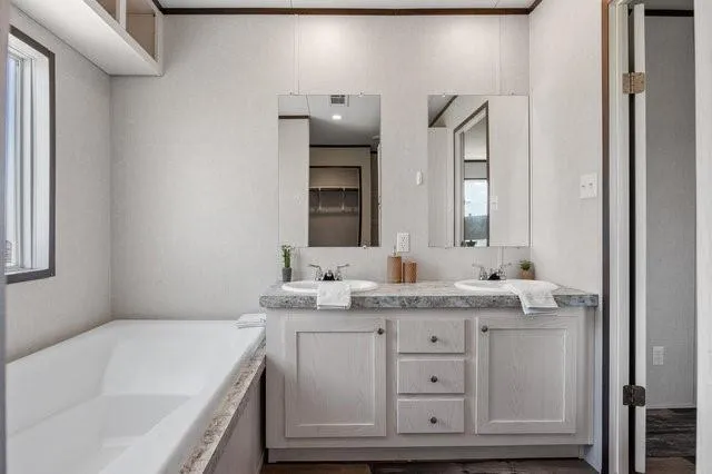a bathroom with a granite countertop sink a large mirror a toilet and vanity