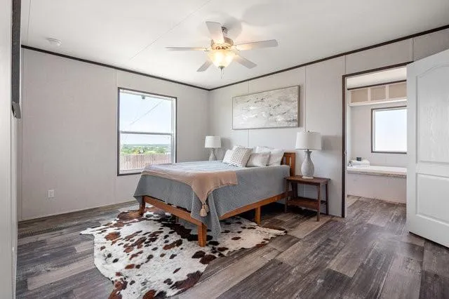 a bedroom with a bed and a table in it with wooden floor
