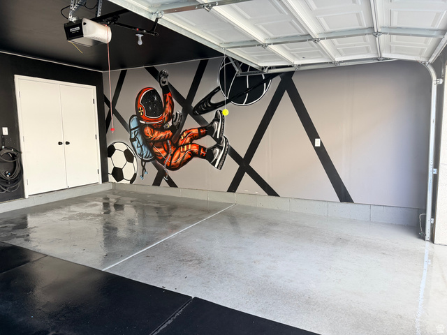 774 West 480 South American Fork, UT 84003 - Photo 71 of 76 Garage space featuring epoxy flooring, a decorative wall mural, and dual white storage doors