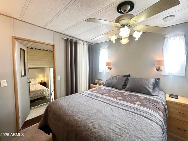 a bedroom with a bed a chandelier and dresser