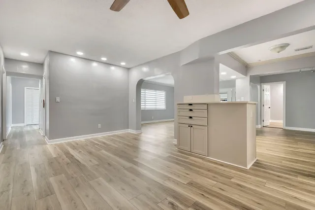 a view of a kitchen with wooden floor and a window