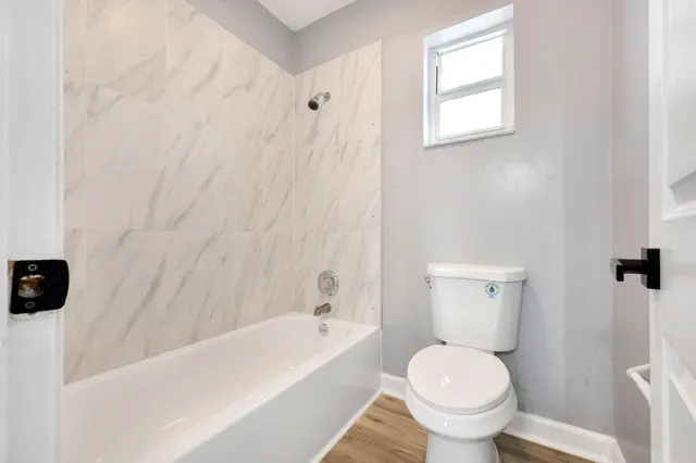 a white toilet sitting next to a bath tub