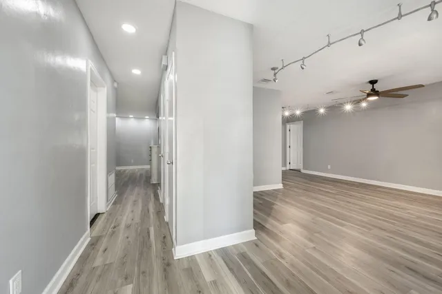 a view of a hallway with wooden floor