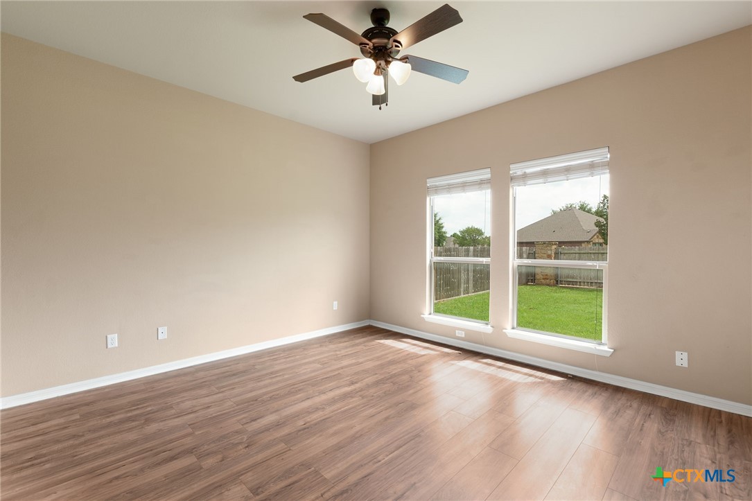 408 Copper Ridge Loop Temple, TX 76502 - Photo 19 of 39 Primary bedroom featuring wood laminate flooring and oversized windows that provide views to the backyard