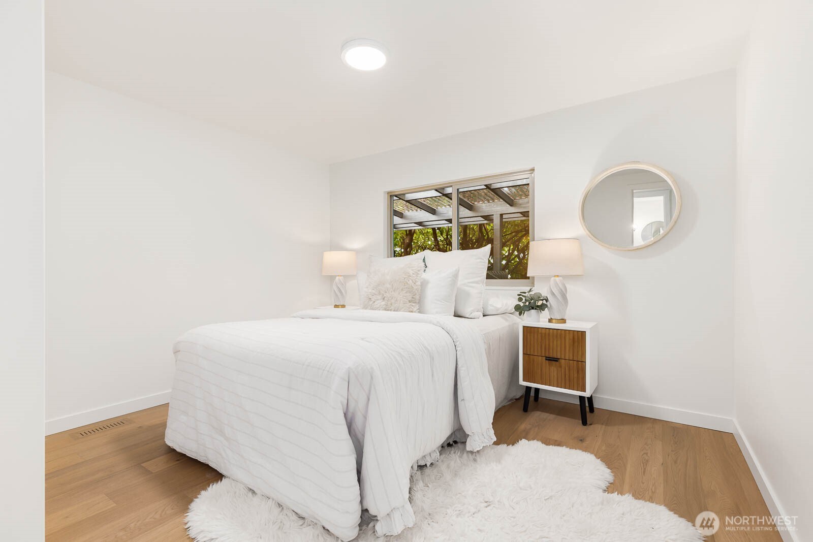 19425 Hollyhills Drive Northeast Bothell, WA 98011 - Photo 20 of 26 a bedroom with a bed and a lamp with wooden floor