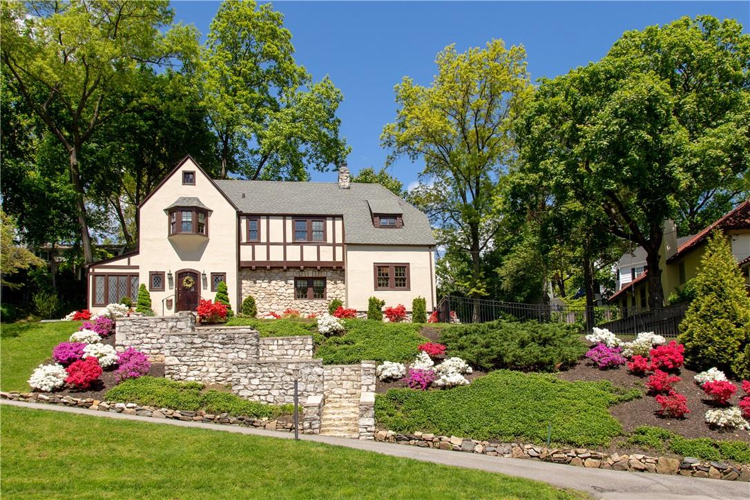 a front view of house with yard and flowers around
