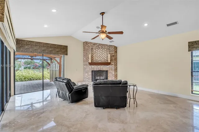 a kitchen with stainless steel appliances kitchen island granite countertop a table chairs and a refrigerator