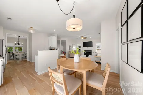 a kitchen with stainless steel appliances granite countertop a dining table chairs and a refrigerator
