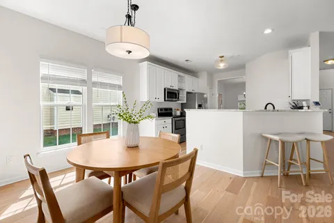 a kitchen with kitchen island a dining table and chairs