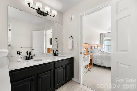 a en suite bathroom with a double vanity sink and a mirror
