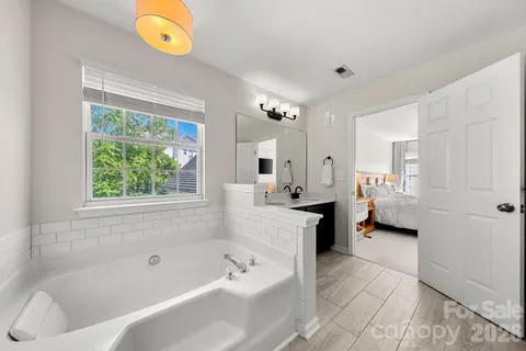 a bathroom with a tub sink and a mirror