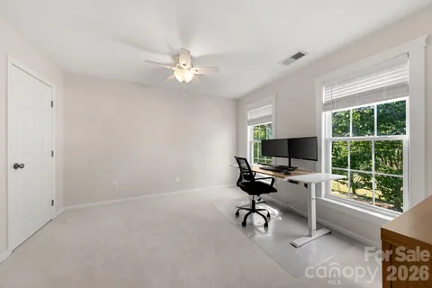 a view of a workspace with furniture and a window