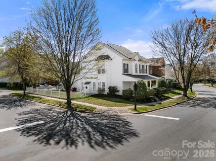 a view of a white house with a big yard and large tree