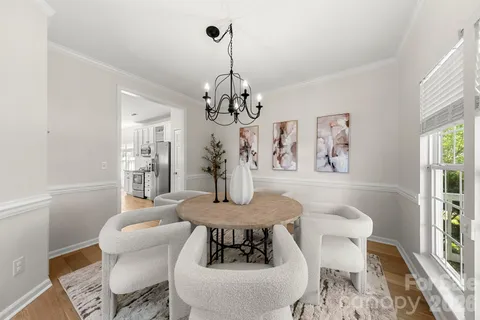 a view of a dining room with furniture wooden floor and a chandelier