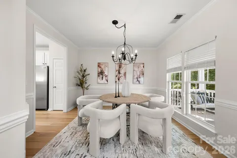 a dining room with furniture a chandelier and wooden floor