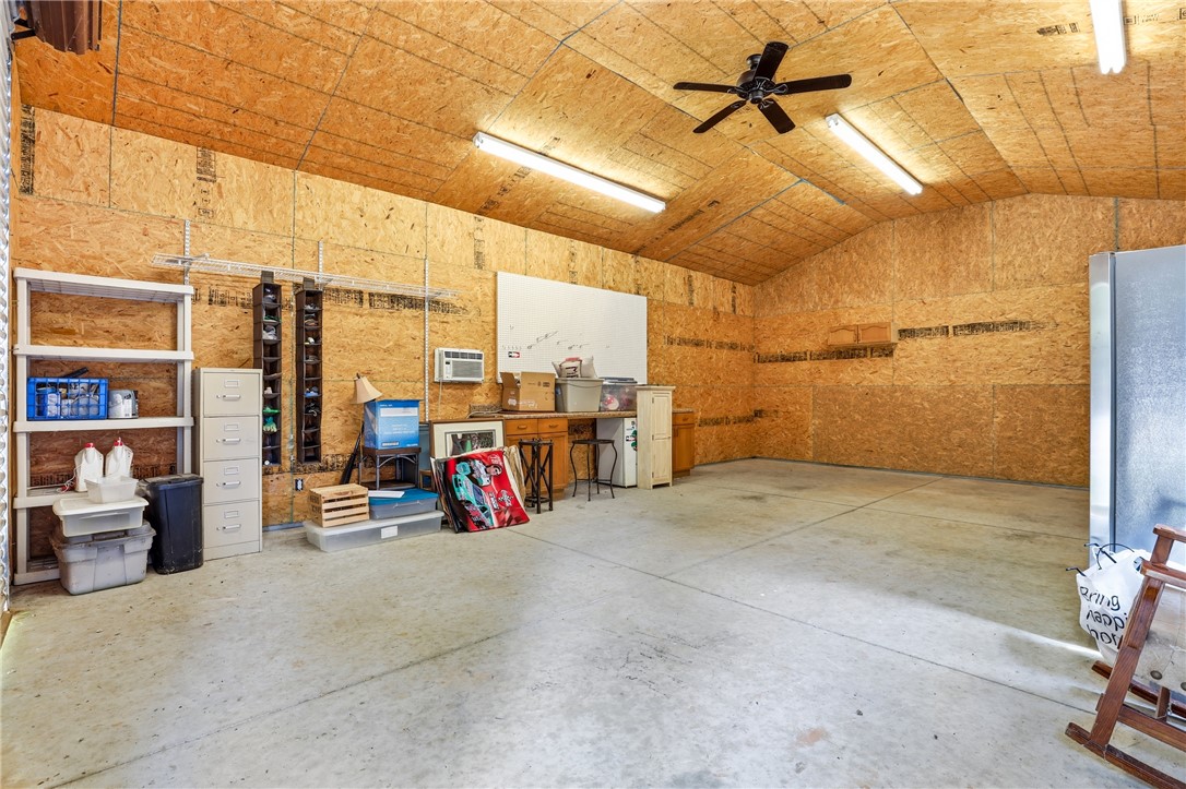 1110 Sunset Lane Anderson, SC 29626 - Photo 18 of 38 A spacious garage/workshop provides boat storage and ample room for projects and storage, featuring a concrete floor and convenient ceiling fan.