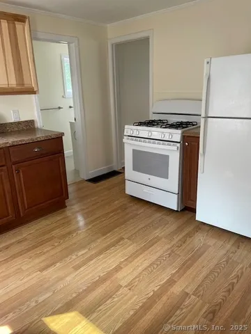 a kitchen with wooden floors and white appliances