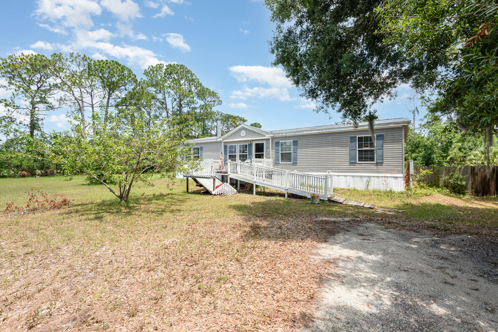 4850 Harrison Road Mims, FL 32754 - Photo 1 of 28 a view of a yard in front of a house with large trees