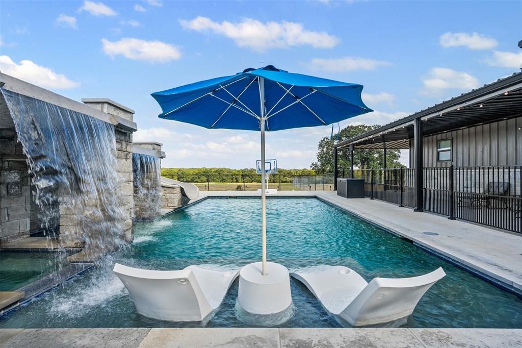 a view of a chair and tables under an umbrella