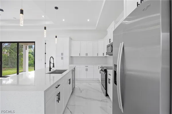 a kitchen with stainless steel appliances a refrigerator sink and cabinets
