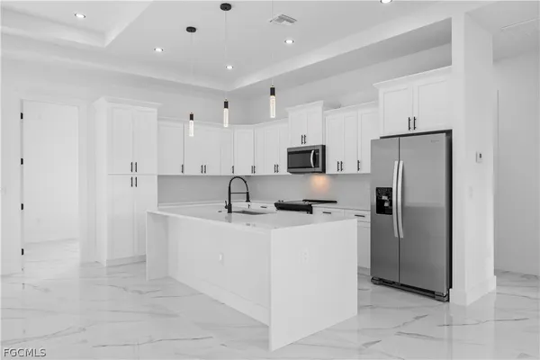 a kitchen with stainless steel appliances a refrigerator sink and microwave