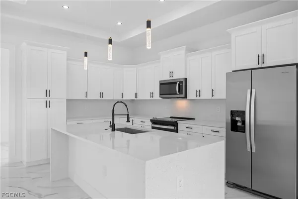 a kitchen with stainless steel appliances a refrigerator sink and microwave