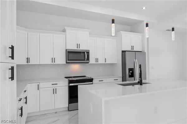 a kitchen with white cabinets and stainless steel appliances