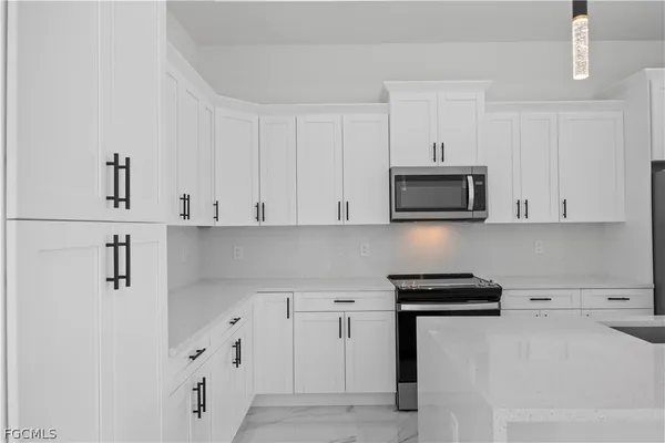 a kitchen with white cabinets and stainless steel appliances