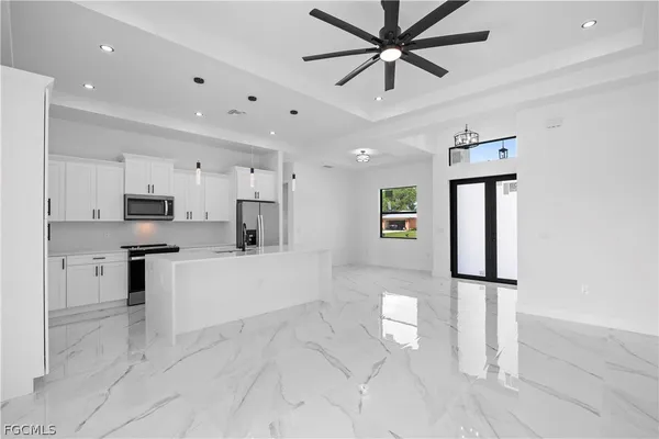 a large white kitchen with cabinets