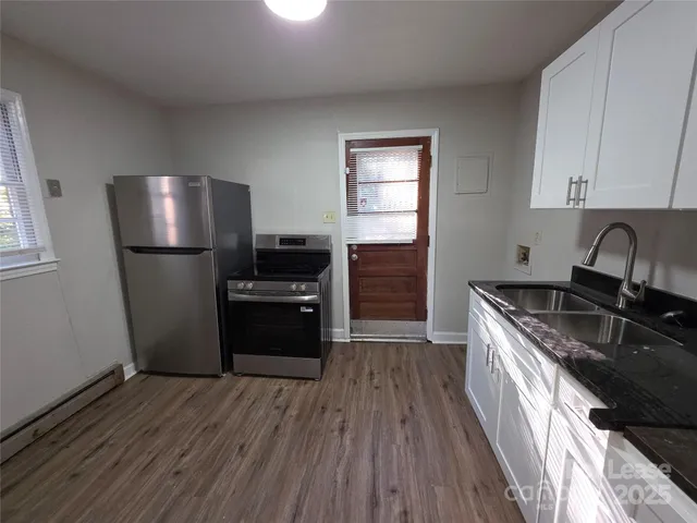a kitchen with a refrigerator sink and wooden floor
