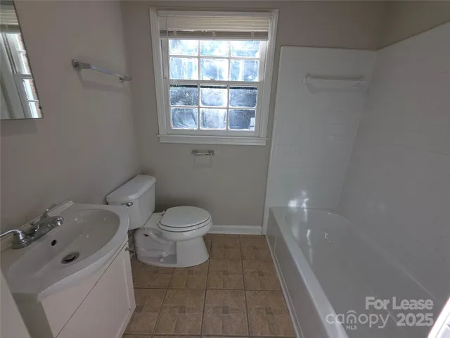 a white toilet sitting next to a bathroom sink