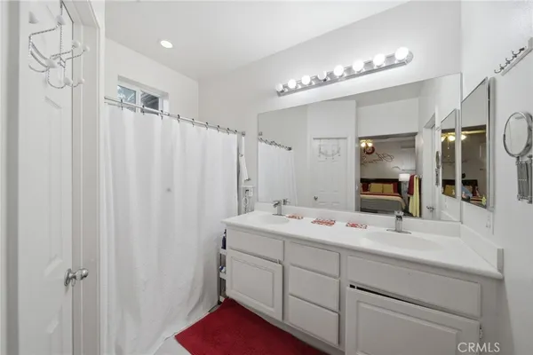 a bathroom with a double vanity sink a mirror a vanity and shower