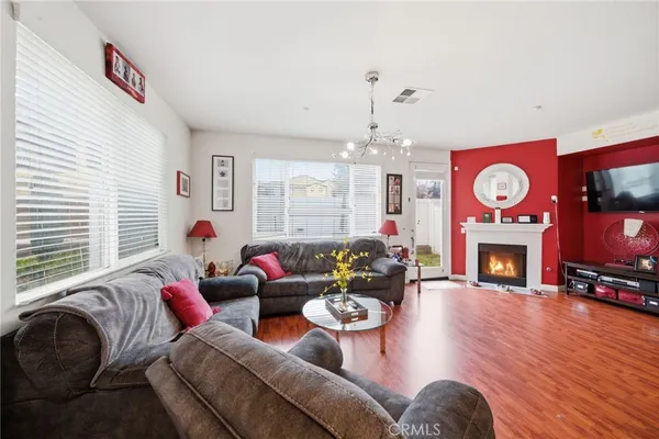 a living room with furniture a fireplace and a chandelier