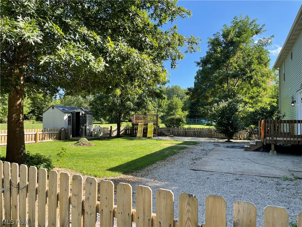 7114 Risden Road Vermilion, OH 44089 - Photo 5 of 35 View of yard with a shed, wooden deck, and a playground
