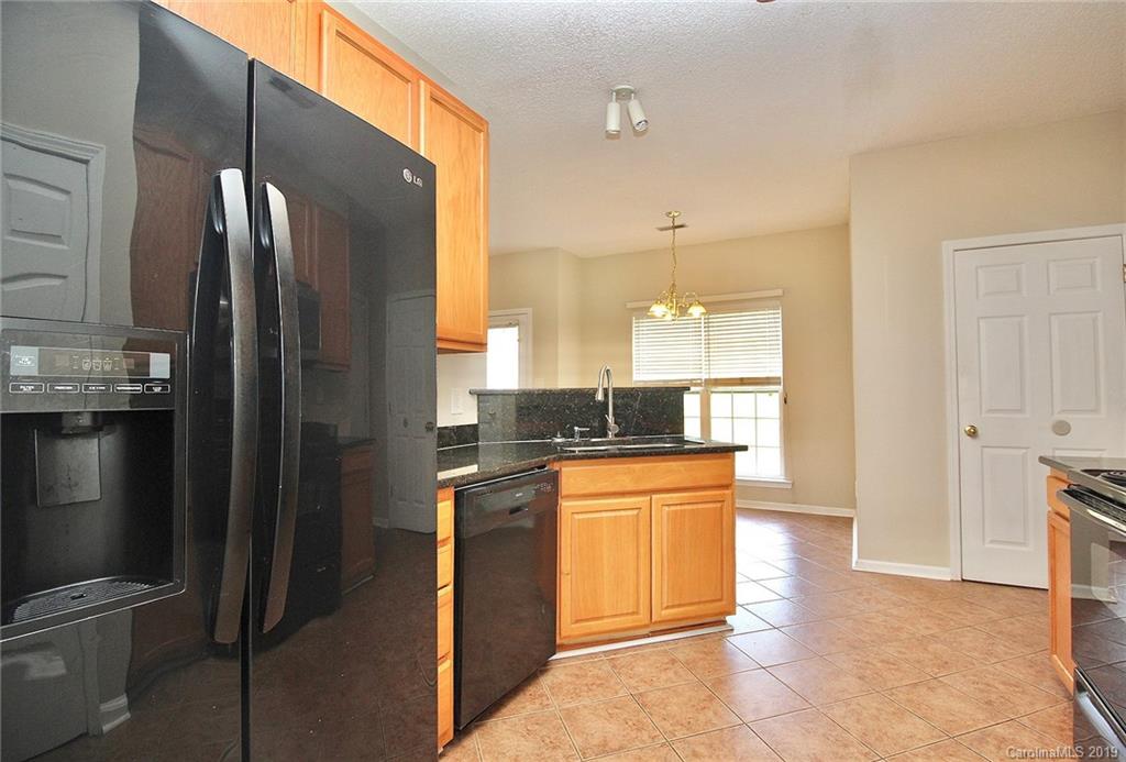 8207 Fox Swamp Road Charlotte, NC 28215 - Photo 11 of 44 a kitchen with stainless steel appliances granite countertop a refrigerator and a sink