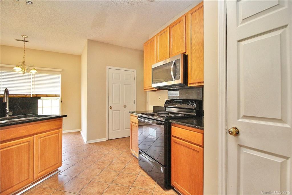 8207 Fox Swamp Road Charlotte, NC 28215 - Photo 12 of 44 a kitchen with stainless steel appliances granite countertop a stove a sink and a microwave