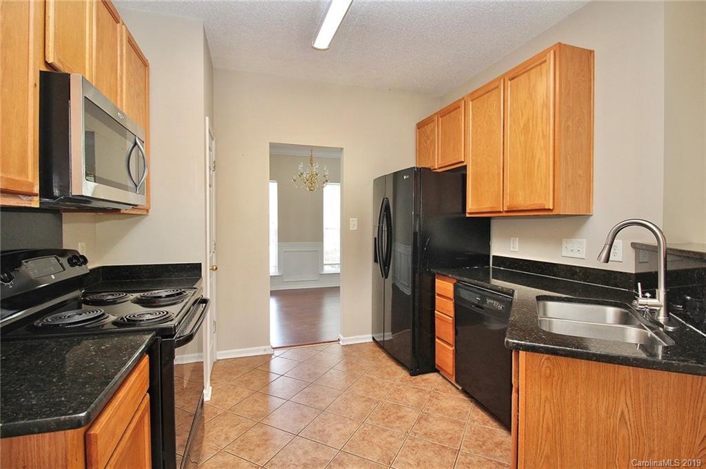 8207 Fox Swamp Road Charlotte, NC 28215 - Photo 13 of 44 a kitchen with stainless steel appliances granite countertop a refrigerator a stove and a sink
