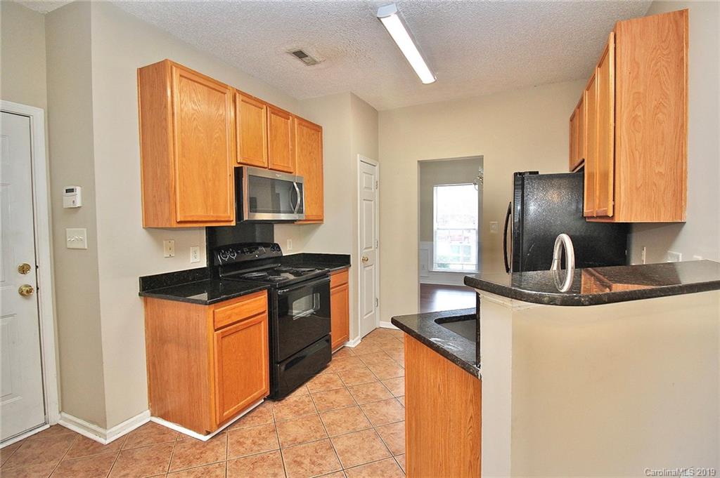 8207 Fox Swamp Road Charlotte, NC 28215 - Photo 14 of 44 a kitchen with stainless steel appliances granite countertop a sink stove and refrigerator