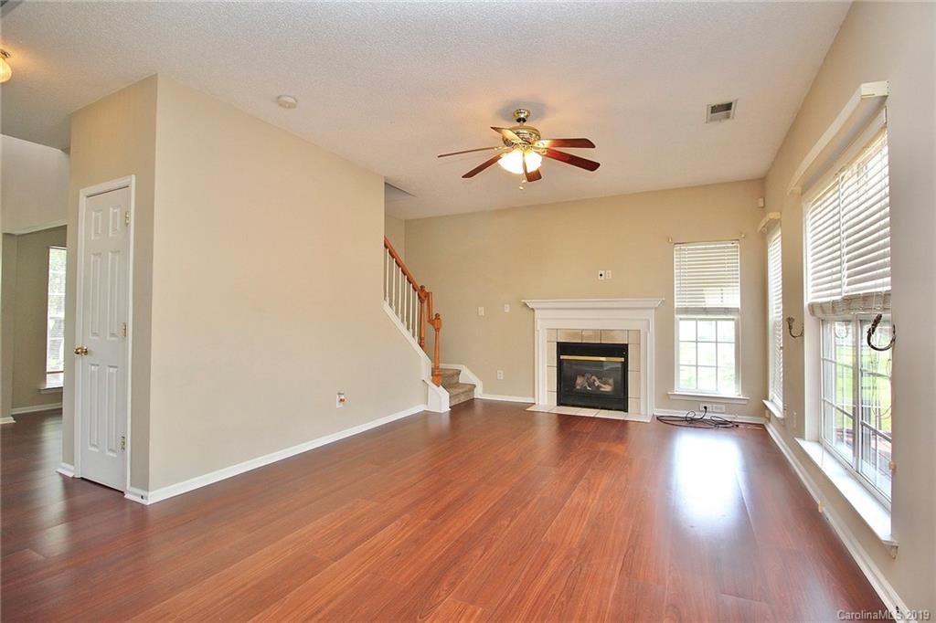 8207 Fox Swamp Road Charlotte, NC 28215 - Photo 19 of 44 an empty room with wooden floor fireplace and windows