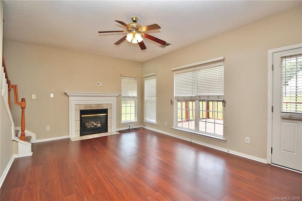 8207 Fox Swamp Road Charlotte, NC 28215 - Photo 20 of 44 an empty room with wooden floor fireplace and windows