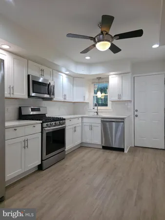 a kitchen with a white cabinets and white stainless steel appliances