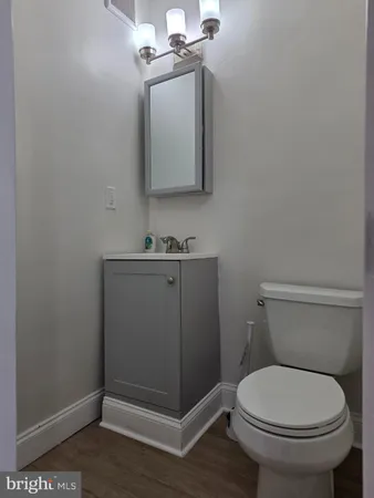 a bathroom with a toilet a sink and mirror