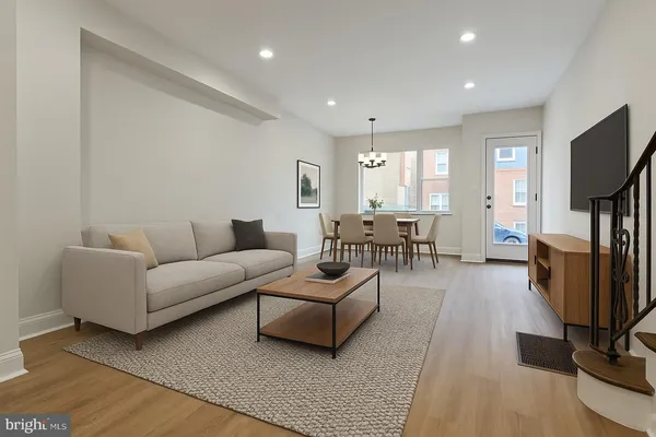 a living room with furniture flat screen tv and windows