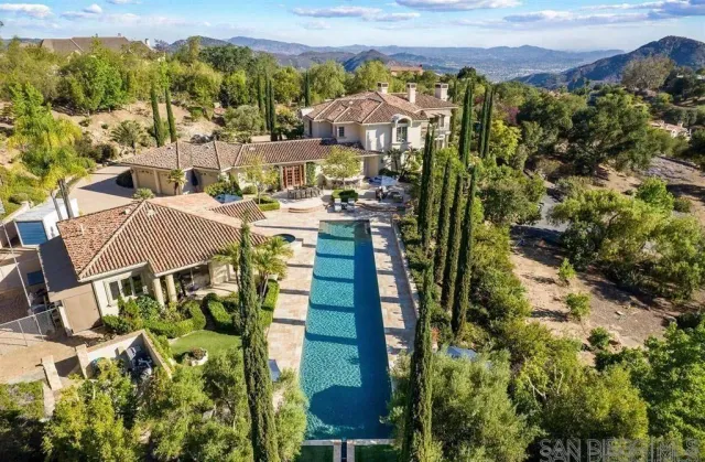 an aerial view of a house with swimming pool and outdoor seating