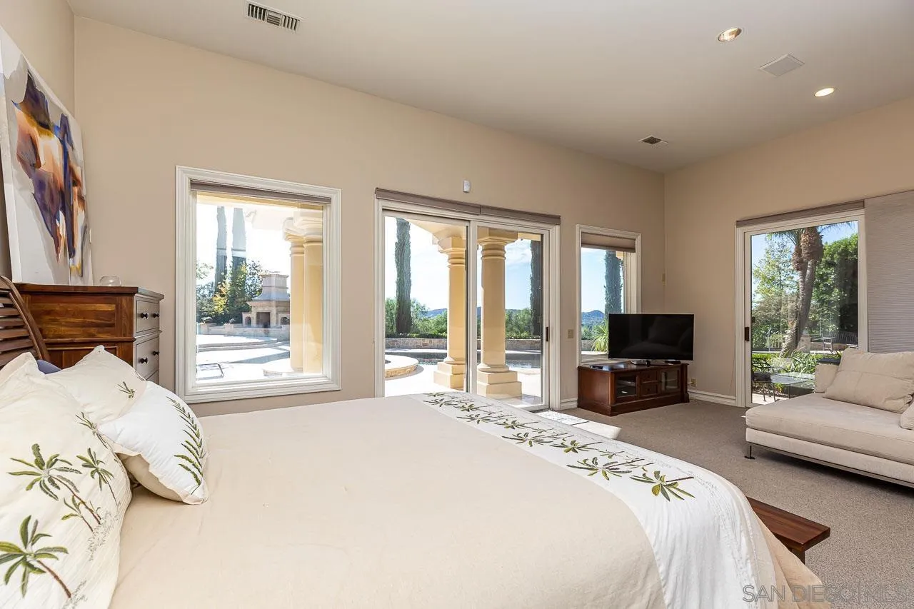 14440 Ridge Ranch Road Valley Center, CA 92082 - Photo 49 of 74 a bedroom with a bed large window couch and a view of living room