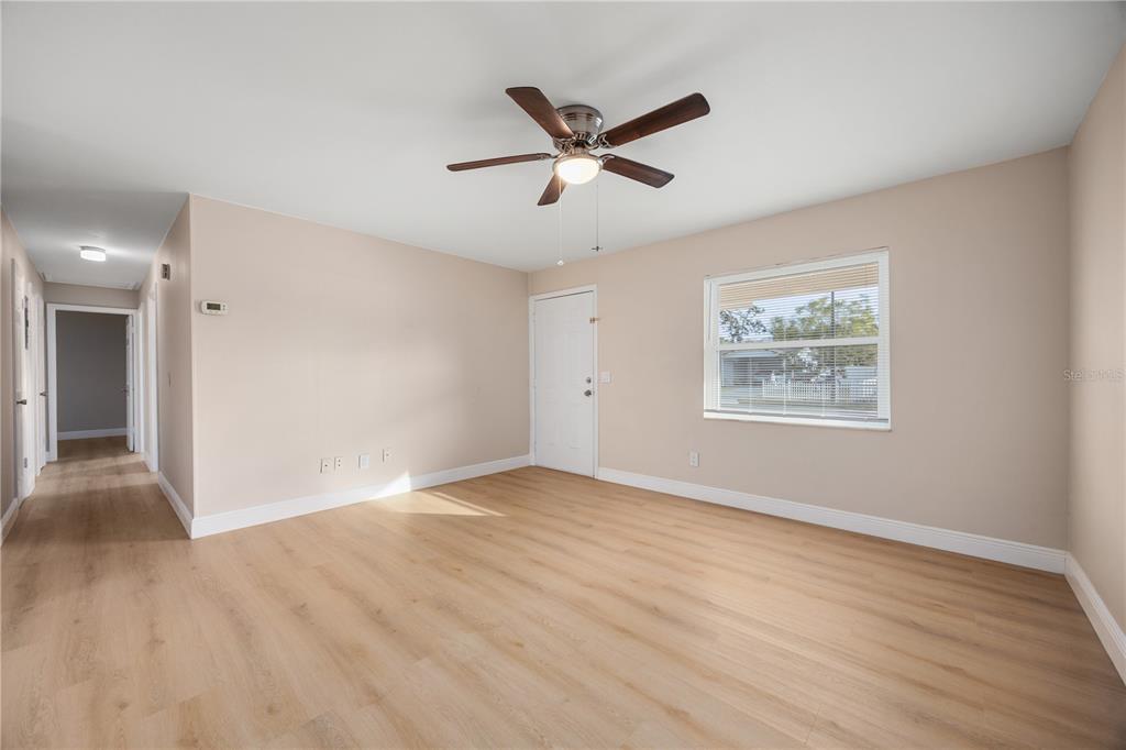 8013 Rhea Circle Orlando, FL 32807 - Photo 16 of 31 a view of an empty room with wooden floor and a ceiling fan