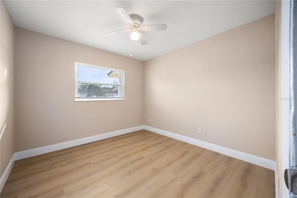 8013 Rhea Circle Orlando, FL 32807 - Photo 22 of 31 an empty room with wooden floor and ceiling fan