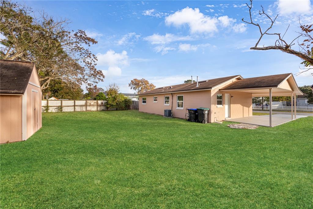 8013 Rhea Circle Orlando, FL 32807 - Photo 29 of 31 a view of a white house next to a yard with big trees